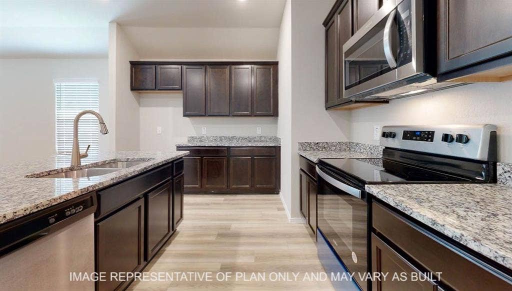 3016 Cyprian Road, Lorena, TX 76655 Kitchen featuring wood-finish flooring, dark wood cabinetry, granite countertops, a stainless steel sink with a high-arc faucet, and stainless steel appliances