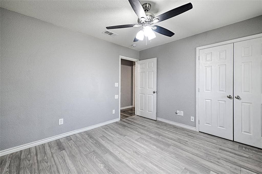 1223 Sequoia Drive, DeSoto, TX 75115 Wood-finish flooring, light gray wall tones, ceiling fan with integrated lighting, and white paneled doors
