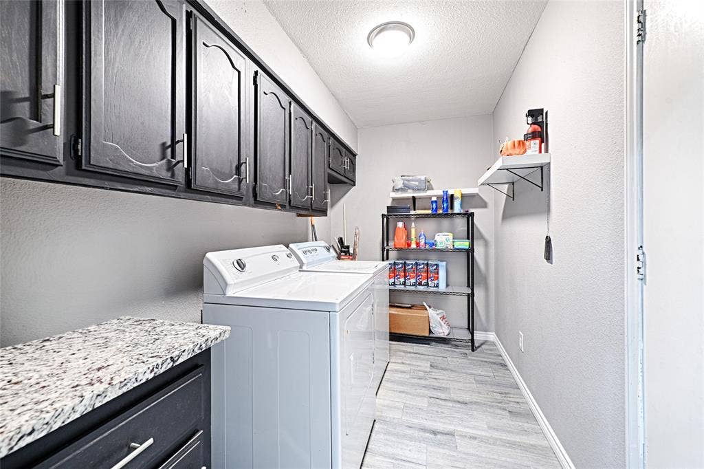 1223 Sequoia Drive, DeSoto, TX 75115 Laundry area with abundant upper cabinetry, a counter surface with a light-toned stone finish, and wood-look flooring