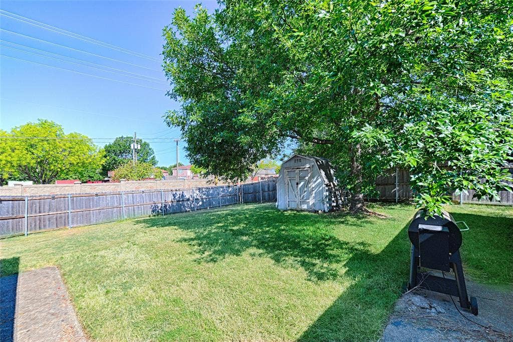 1223 Sequoia Drive, DeSoto, TX 75115 Expansive fenced backyard featuring a storage shed and mature trees
