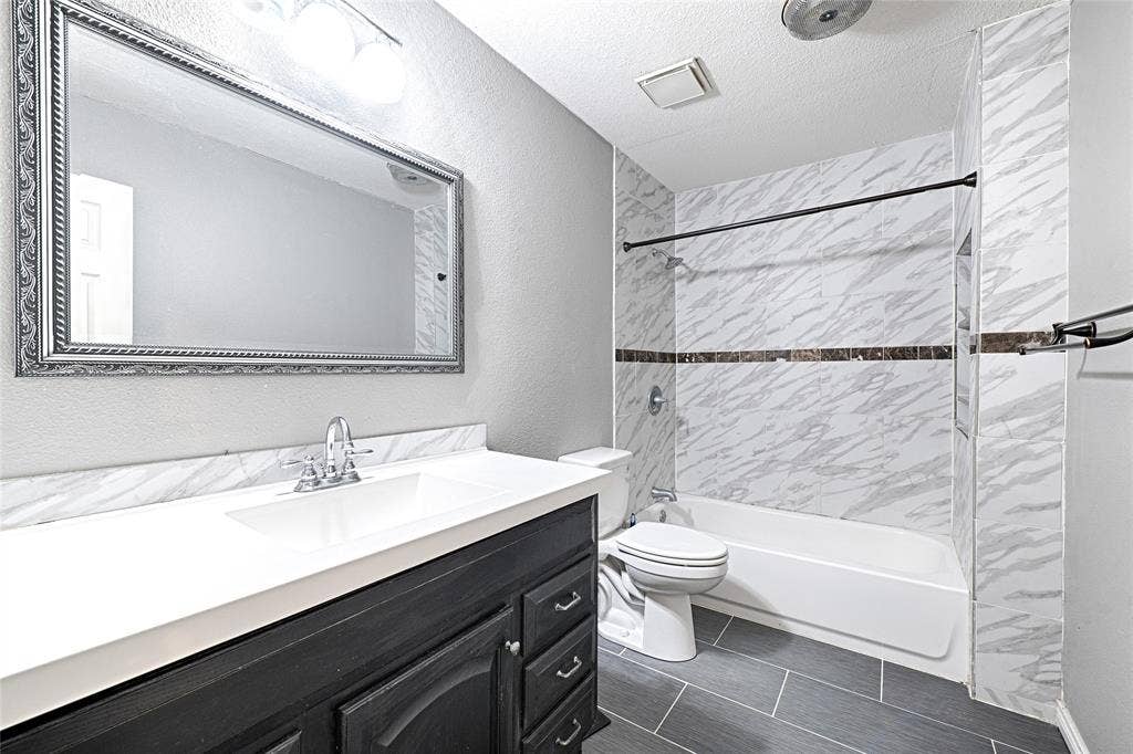 1223 Sequoia Drive, DeSoto, TX 75115 Bathroom featuring a single vanity with a white countertop, chrome faucet, and dark wood-finish cabinetry