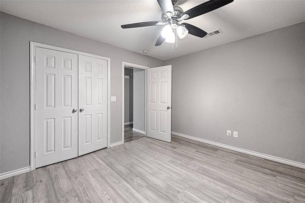 1223 Sequoia Drive, DeSoto, TX 75115 Wood-finish flooring, ceiling fan with light fixture, neutral wall color, white trim, and bi-fold closet doors