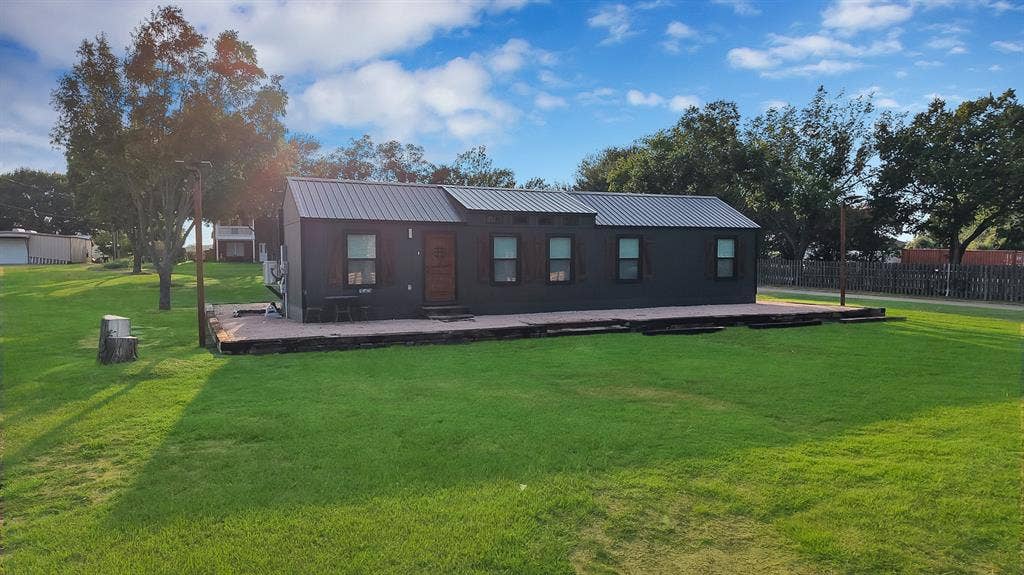 Dark-toned exterior with a metal roof and wood shutters