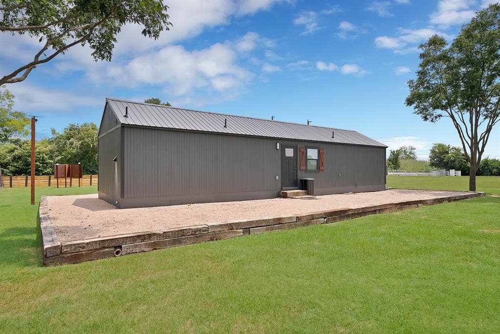 Gable-roof structure with a metal roof and board and batten siding