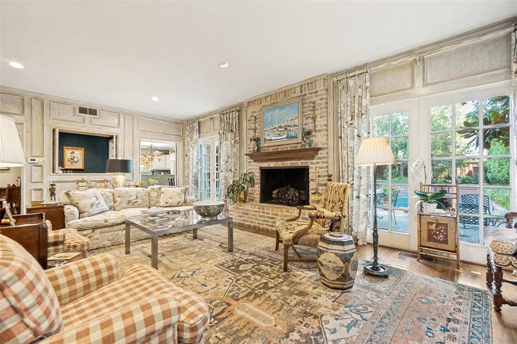 3418 Dartmouth Avenue, Highland Park, TX 75205 Brick fireplace with a wood mantel, paneled walls, and French doors