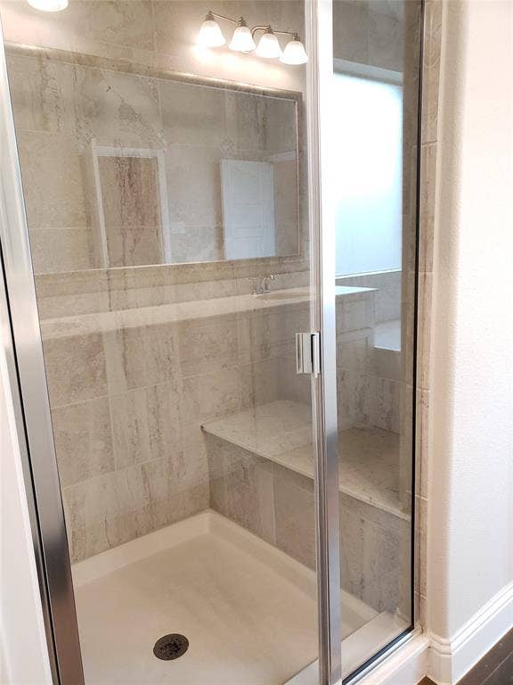 940 Parkside Drive, Argyle, TX 76226 Primary Bath with Glass-enclosed shower with a built-in bench, tiled walls, and a shower pan