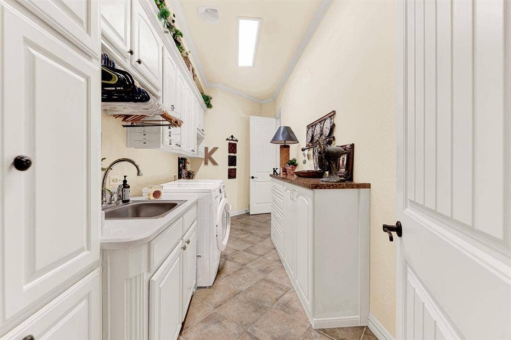 7032 PORTOBELLO Drive, Plano, TX 75024 An integrated utility sink and dual storage banks line the pass-through hallway leading directly to the primary suite. Tackle household chores with ease in a bright, thoughtful layout designed for seamless daily flow.