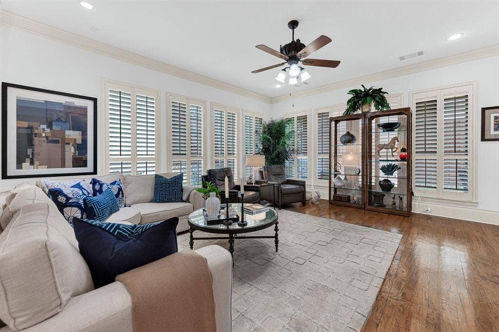 7032 PORTOBELLO Drive, Plano, TX 75024 A expansive bank of floor-to-ceiling plantation shutters diffuses soft daylight across rich oak flooring. Unwind with your favorite book as gentle afternoon light filters through the quiet space.