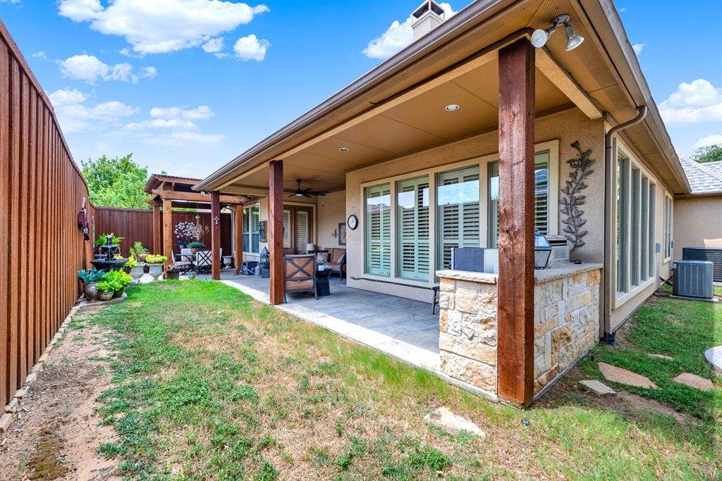 7032 PORTOBELLO Drive, Plano, TX 75024 A built-in stone grill station anchors the shaded veranda beneath a high porch ceiling. Visualize serving fresh appetizers to guests as afternoon shadows stretch gracefully across the yard. Expansive window banks flood the home with sunshine while connecting to a circular stone patio pad. Enjoy a quiet weekend afternoon listening to the breeze rustle through mature shade trees.