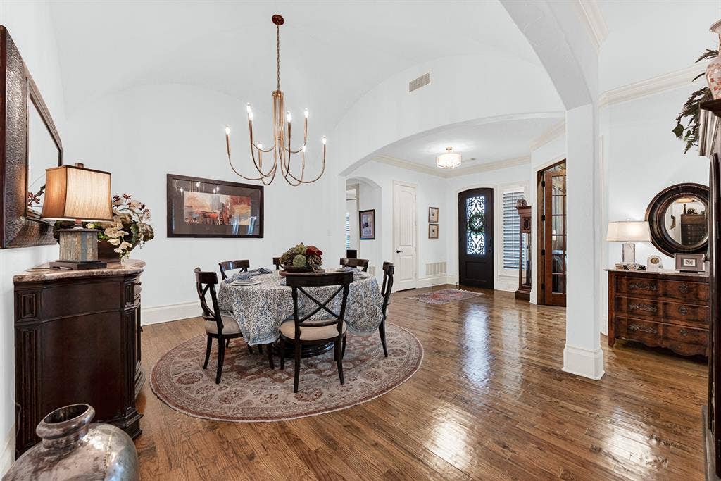 7032 PORTOBELLO Drive, Plano, TX 75024 A dramatic groined vault ceiling catches light softly, adding architectural grandeur above rich hardwood floors. Imagine setting the table for holiday gatherings, surrounded by warm, glowing light and elegant spatial flow