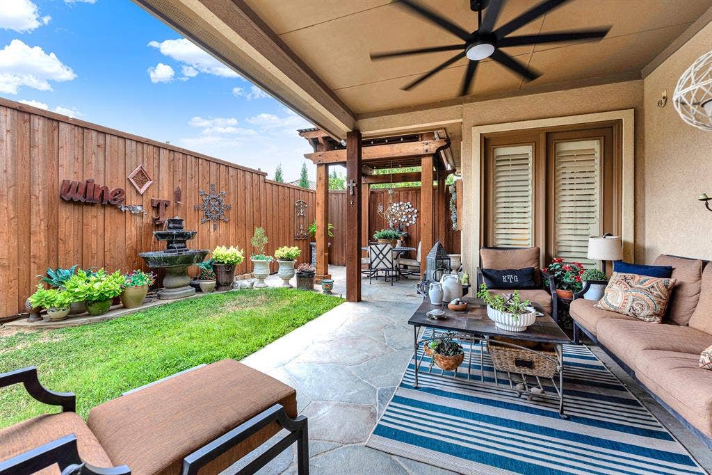 7032 PORTOBELLO Drive, Plano, TX 75024 Stamped, flagstone-textured concrete extends seamlessly beneath a cooling ceiling fan and handsome wooden pergolas. Unwind after work with a chilled drink, listening to the soothing trickle of nearby water features.