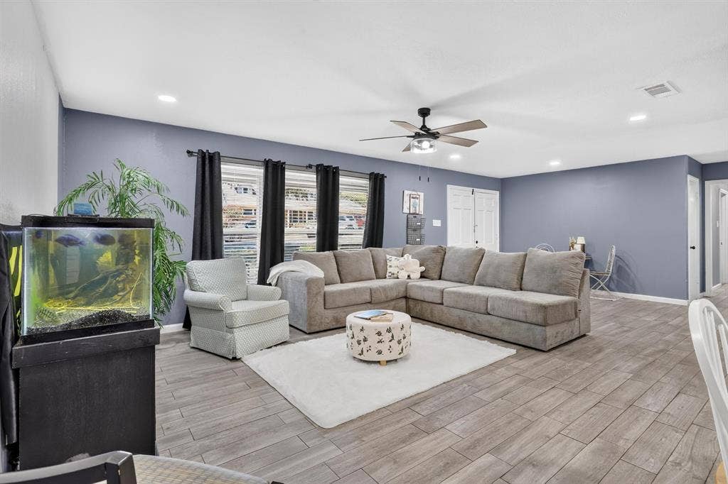 8117 Rush Street, Benbrook, TX 76116 Spacious open-concept living area featuring a sectional configuration, plush seating arrangement, and neutral wood-finish flooring throughout