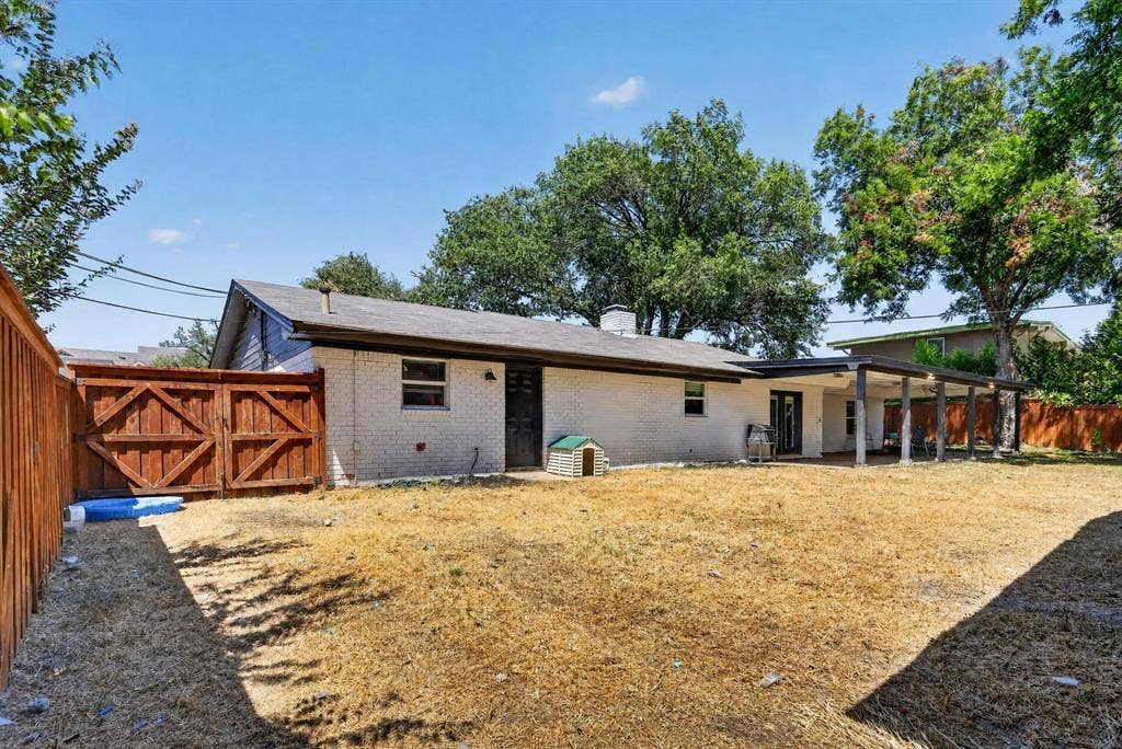 8117 Rush Street, Benbrook, TX 76116 Spacious residential property featuring a brick exterior, covered porch with wooden support beams, and a large cleared lot with mature trees