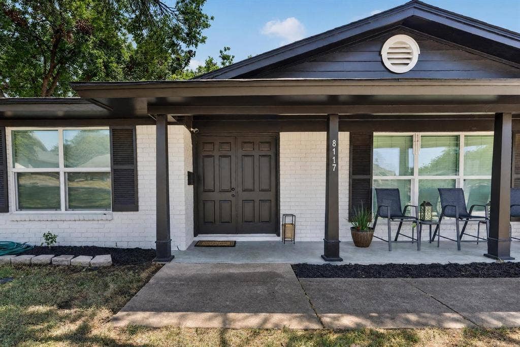 8117 Rush Street, Benbrook, TX 76116 White brick exterior with dark trim and shutters, covered front porch, and double entry doors