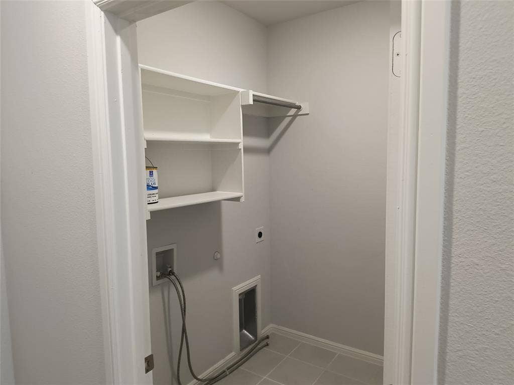 320 Leopold Trail, Greenville, TX 75402 White built-in shelving, metal hanging rod, and light gray tiled flooring