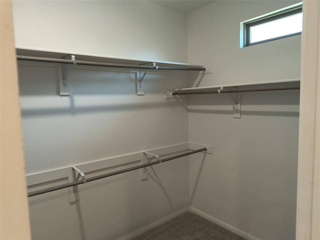 320 Leopold Trail, Greenville, TX 75402 Walk-in closet featuring multiple shelving units, hanging rods, and a high-set window