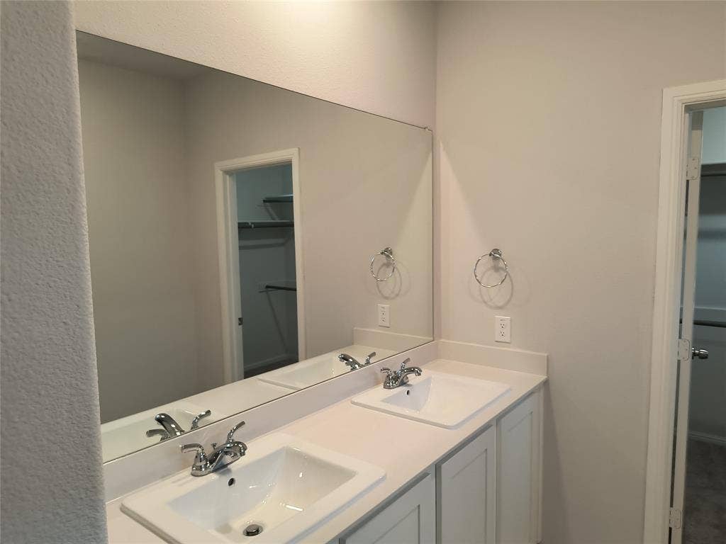 320 Leopold Trail, Greenville, TX 75402 Double vanity with integrated sinks, white countertops, and chrome faucets