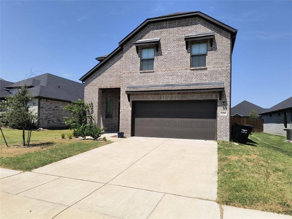 320 Leopold Trail, Greenville, TX 75402 Brick exterior with attached garage, concrete driveway, and covered entry