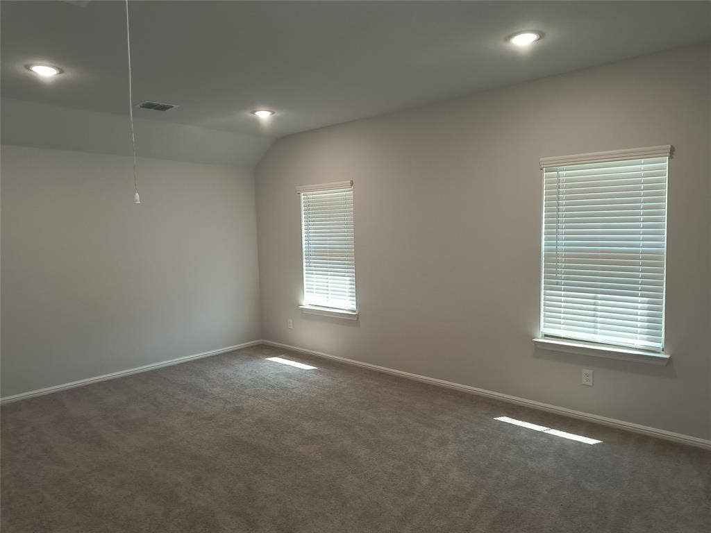 320 Leopold Trail, Greenville, TX 75402 Recessed lighting, sloped ceiling, two windows with blinds, and carpet flooring