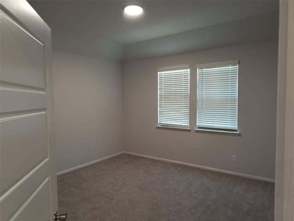 320 Leopold Trail, Greenville, TX 75402 Recessed ceiling lighting, two windows with blinds, light gray wall paint, and gray carpeting