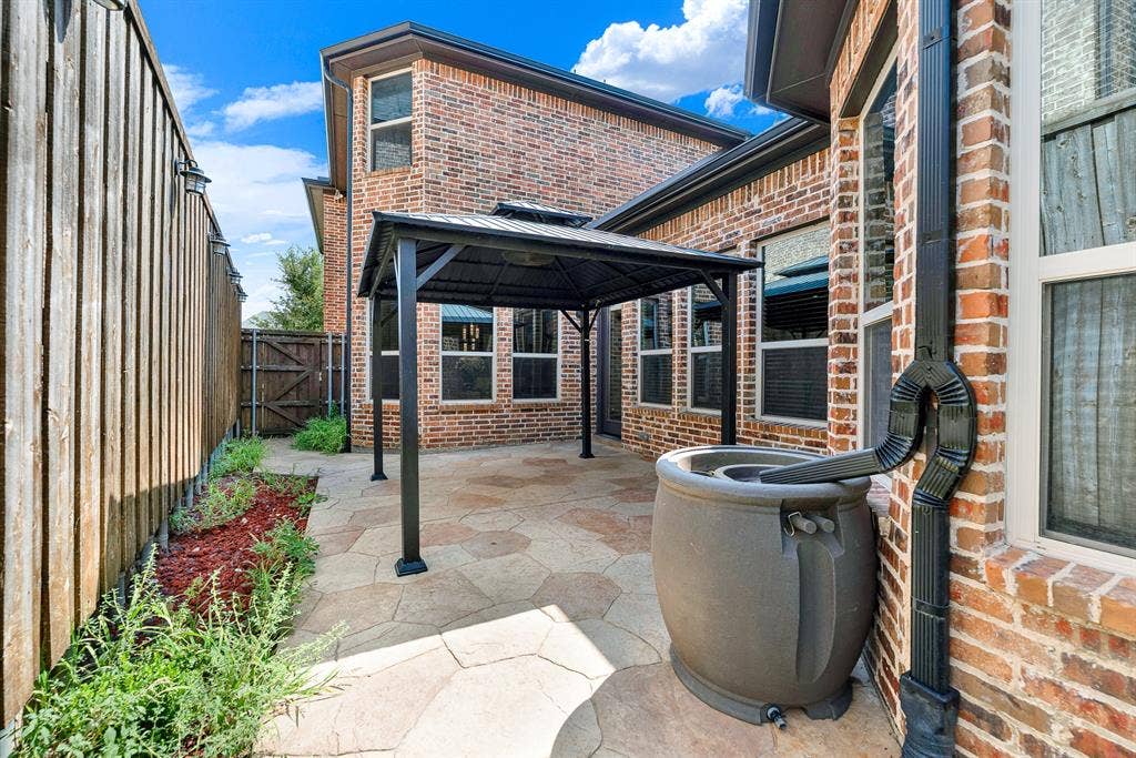 7013 BROOK FOREST Circle, Plano, TX 75024 Generous rear rooflines and integrated gutter downspouts wrap around the shaded stone terrace, capturing crisp sky views above. Envision stepping outside on breezy spring afternoons to tend potted herbs and chat with neighbors across the courtyard.