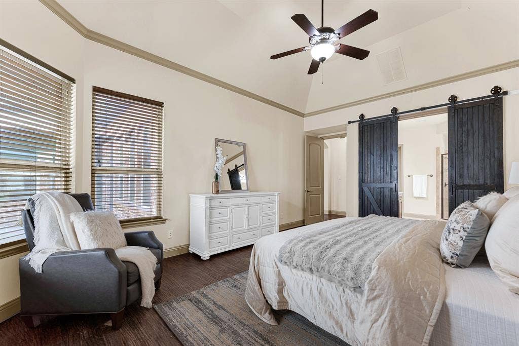 7013 BROOK FOREST Circle, Plano, TX 75024 Rustic black double barn doors on matte iron tracking form a bold entryway to the en-suite bath. It sets the tone for tranquil nighttime wind-downs, sliding the doors open for a warm, restorative soak.