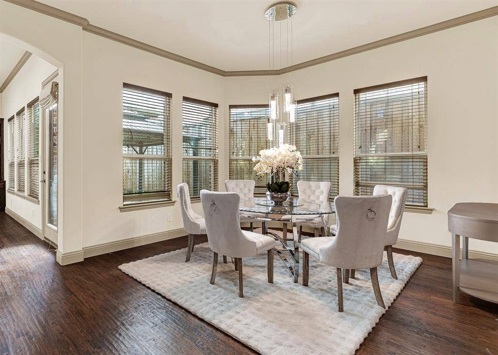 7013 BROOK FOREST Circle, Plano, TX 75024 An angled bay of expansive windows wraps the nook, catching soft daylight against the rich, dark-toned flooring. Picture easy Sunday mornings here, savoring fresh coffee and warm pastries while golden rays gently filter in.