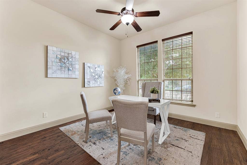 7013 BROOK FOREST Circle, Plano, TX 75024 Side-by-side front windows wash the corner in balanced daylight, complemented by high-volume walls and rich plank flooring adorning the first floor guest room. Imagine setting up a dedicated remote workspace or welcoming overnight guests to a quiet, sunlit sanctuary.