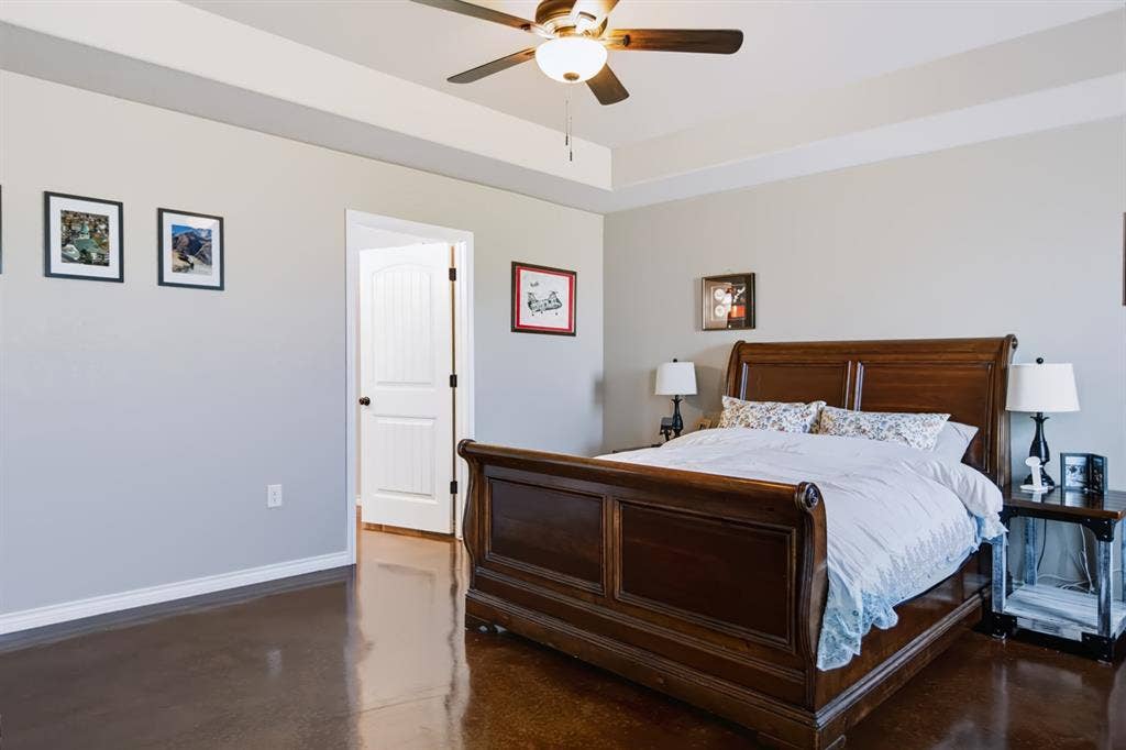 2433 Trlica Road, West, TX 76691 Tray ceiling with a ceiling fan light fixture, white interior door, and dark wood-finish flooring