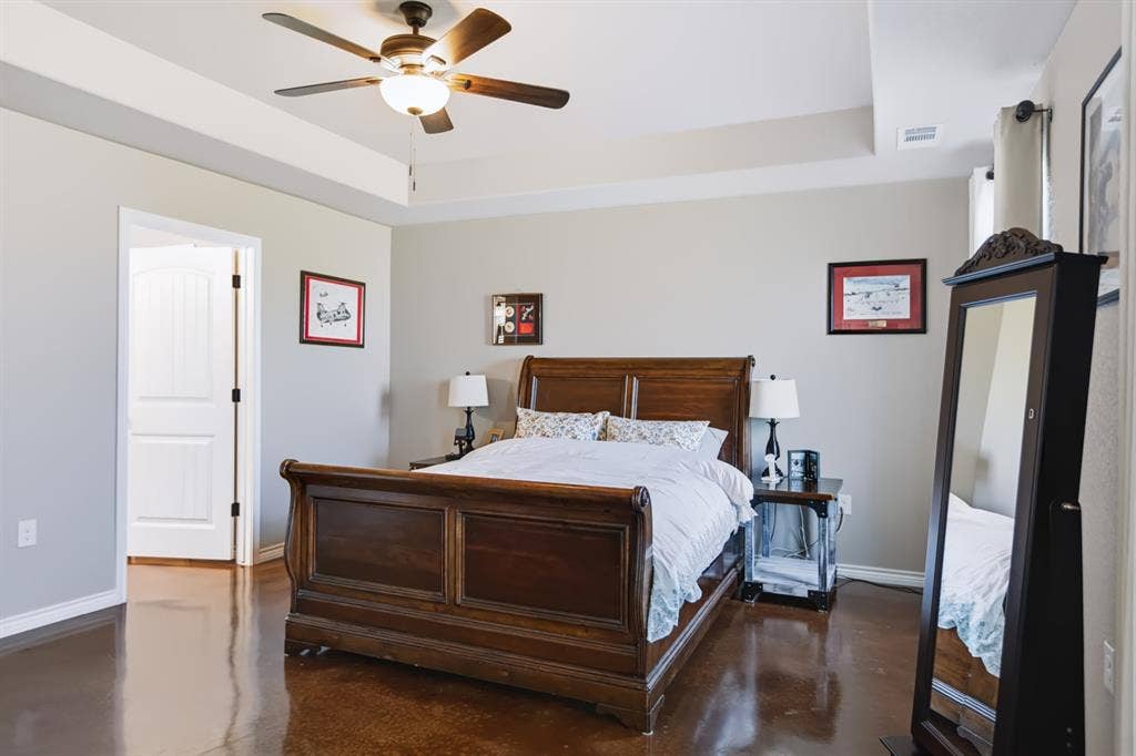 2433 Trlica Road, West, TX 76691 Tray ceiling with a ceiling fan, wood-finish flooring, and white paneled interior doors