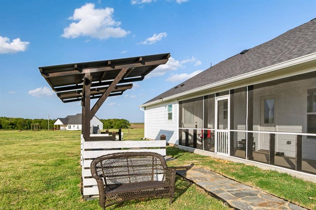 2433 Trlica Road, West, TX 76691 Expansive green space featuring a screened-in porch, patio with a wood pergola, and flagstone pathway