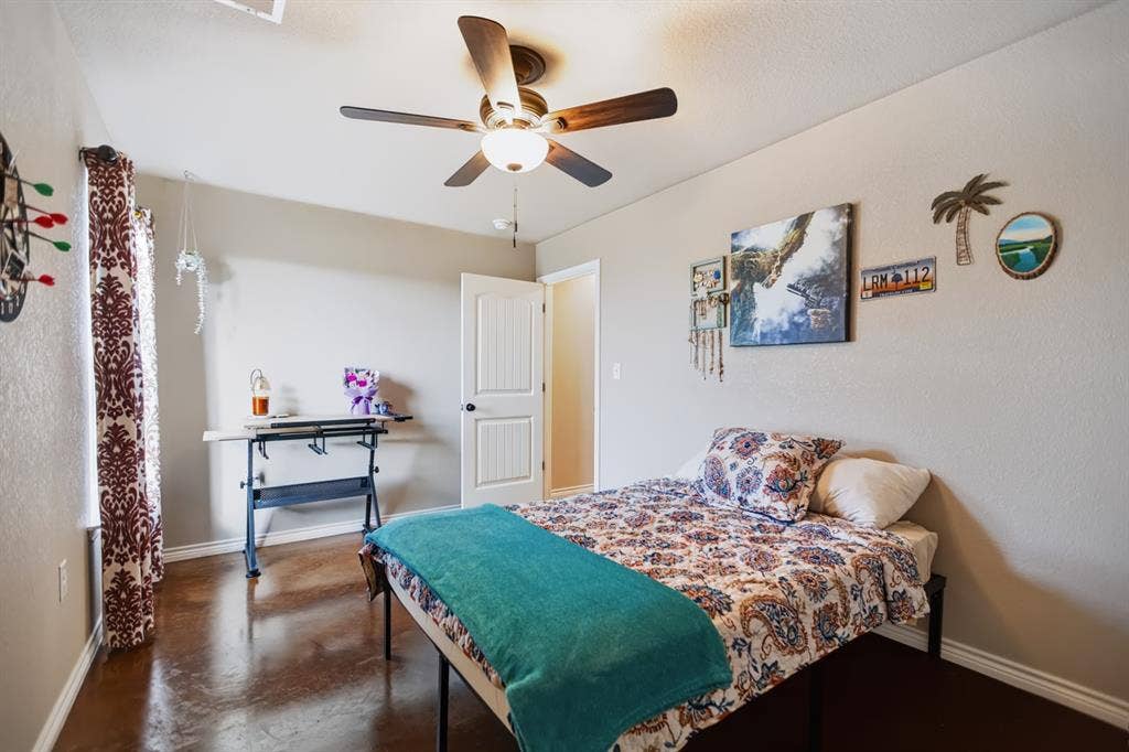2433 Trlica Road, West, TX 76691 Guest Room 3Smooth concrete flooring, ceiling fan with integrated lighting, white interior door, and neutral wall tones