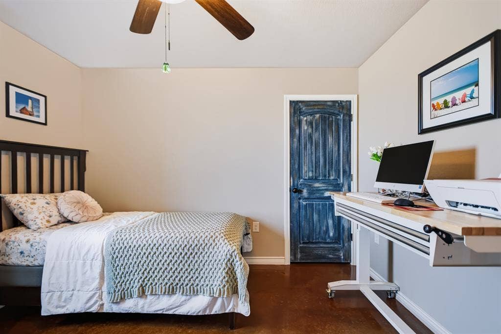 2433 Trlica Road, West, TX 76691 Guest Room 1Warm tone walls, brown wood-finish flooring, and a ceiling fan with light fixture