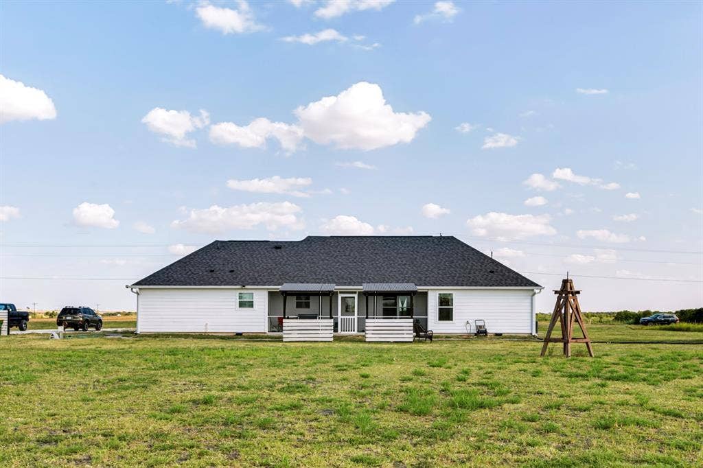2433 Trlica Road, West, TX 76691 Rear exterior featuring white horizontal siding, dark shingle roof, and a covered patio