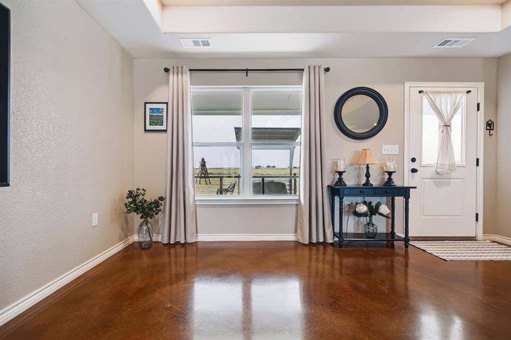 2433 Trlica Road, West, TX 76691 Tray ceiling, wood-finish flooring, white window trim, white baseboards, and a white paneled door