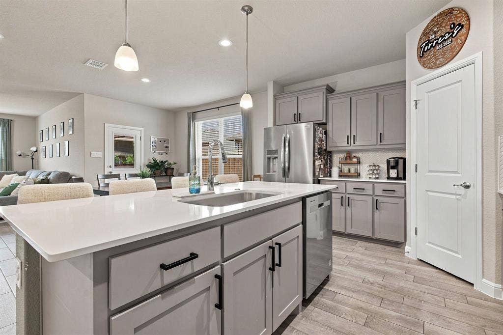 Kitchen island with a white solid surface countertop and undermount sink