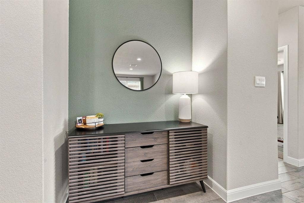 Built-in alcove featuring a decorative mirror, neutral wall paint, and recessed lighting