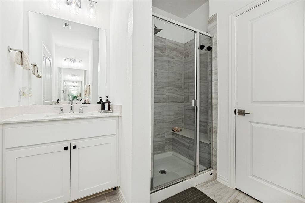 7536 Laburnam Road, Dallas, TX 75228 Vanity with integrated sink, white cabinetry, and polished chrome fixtures