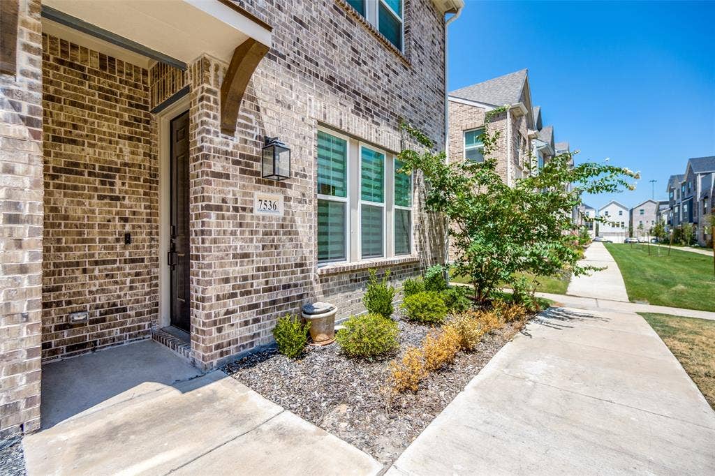 7536 Laburnam Road, Dallas, TX 75228 Brick exterior with an entryway featuring an overhang, a decorative sconce, and a front door with a transom window