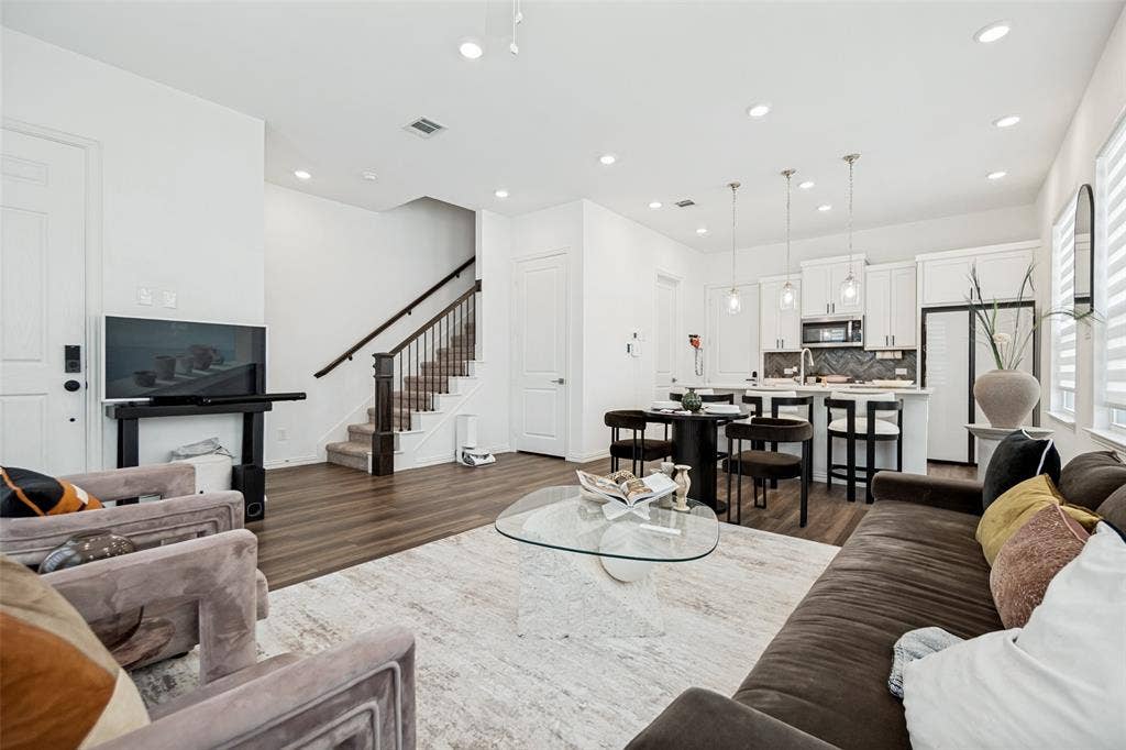 7536 Laburnam Road, Dallas, TX 75228 Open-concept living area with wood-finish flooring, recessed lighting, and a prominent staircase with dark wood railings