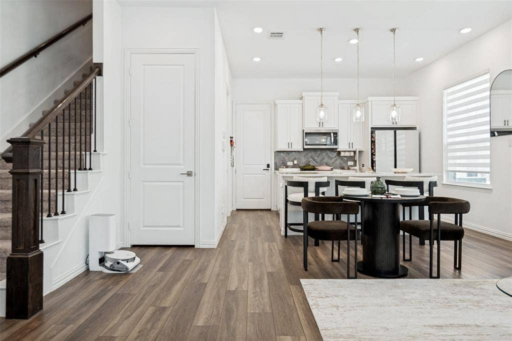 7536 Laburnam Road, Dallas, TX 75228 Open-concept living space with wood-finish flooring, a contemporary kitchen, white cabinetry, stainless steel appliances, and recessed lighting