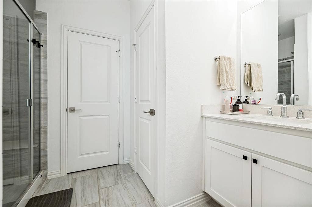 7536 Laburnam Road, Dallas, TX 75228 Dual vanity with undermount sinks, stone countertop, and chrome fixtures