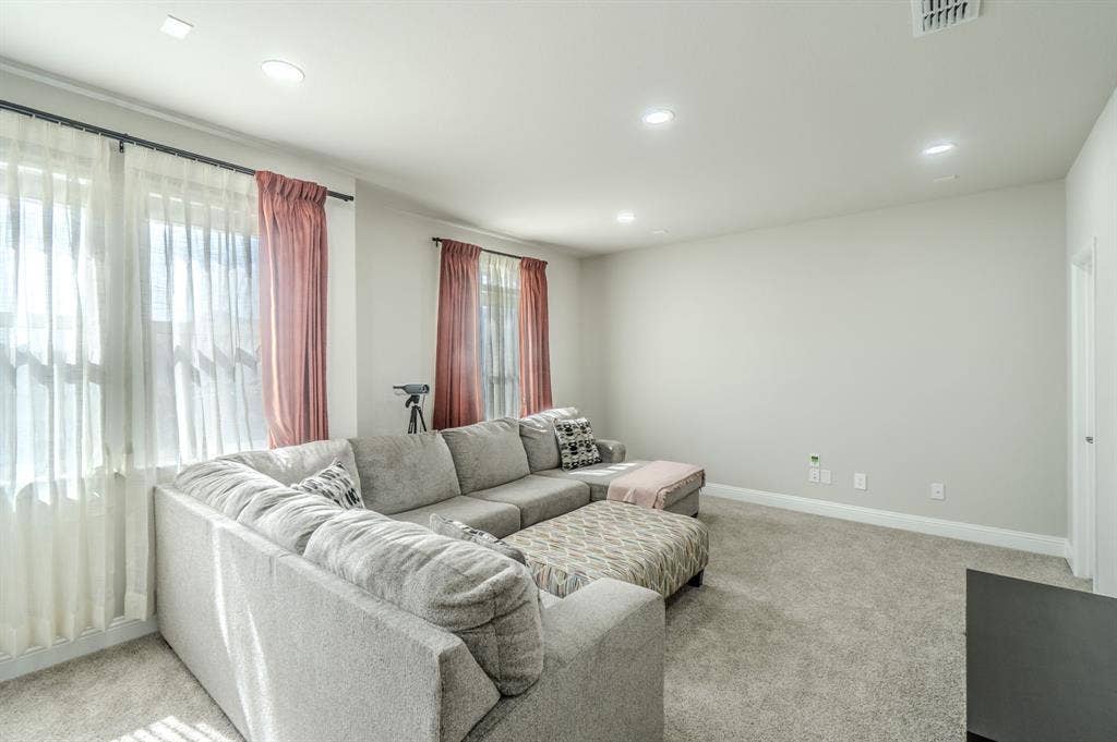 Recessed lighting, light gray wall paint, white trim, and light-colored carpeting