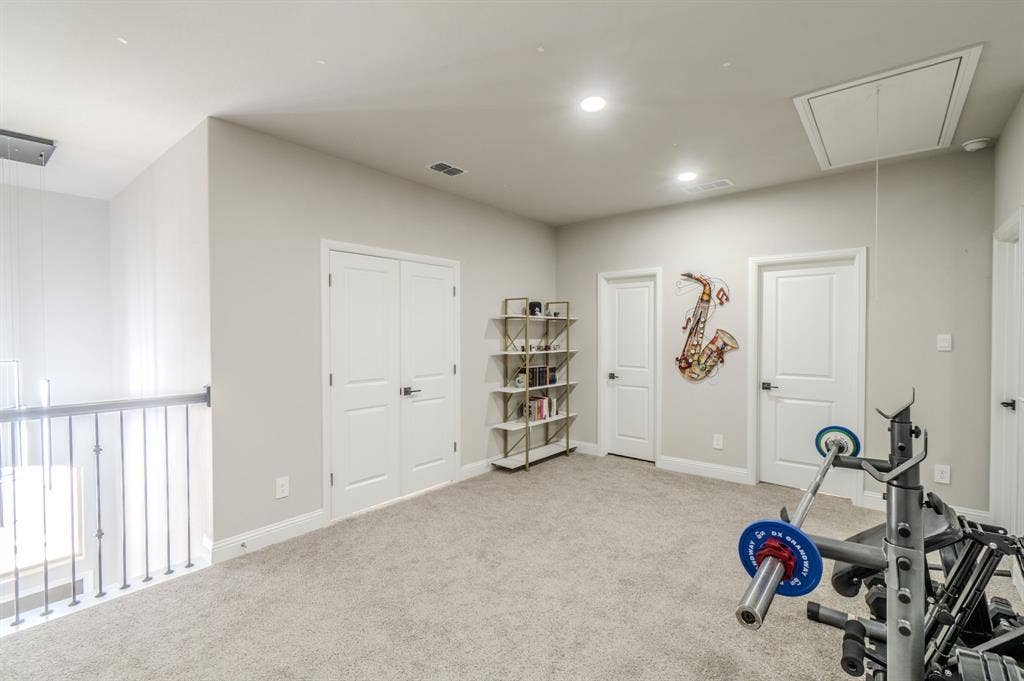 Carpeted loft area featuring recessed lighting and multiple panel doors