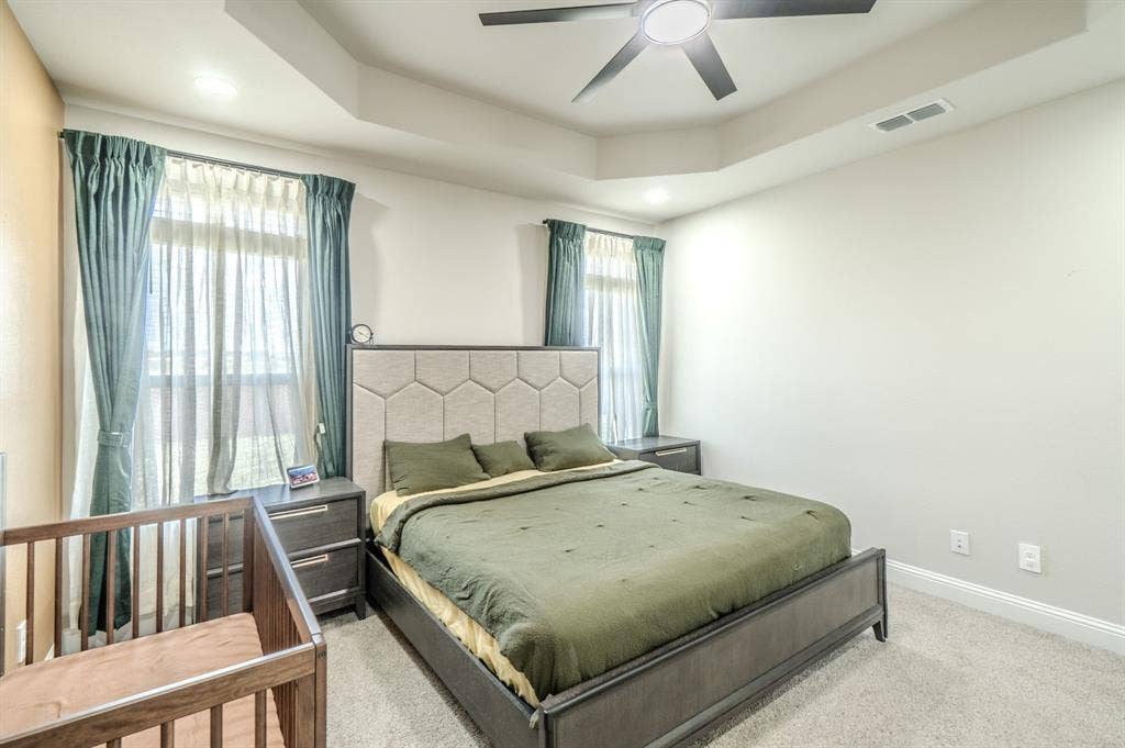 Tray ceiling with recessed lighting and a ceiling fan, light-toned wall finishes, and carpet flooring