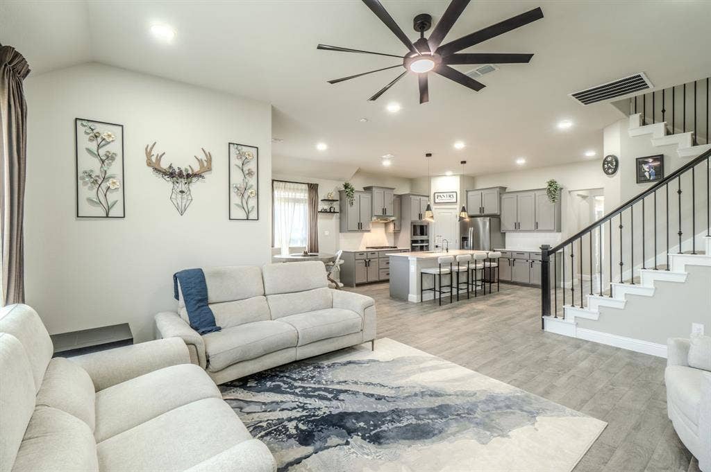 Open-concept living space featuring wood-finish flooring, recessed lighting, and a modern ceiling fan