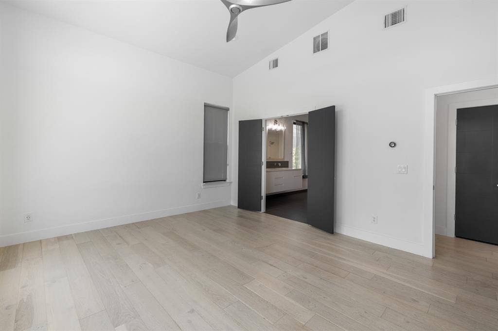 1321 Black Walnut Lane, Arlington, TX 76005 Spacious primary living area featuring wide-plank wood-finish flooring, soaring ceilings with ceiling fan, and multiple entry points