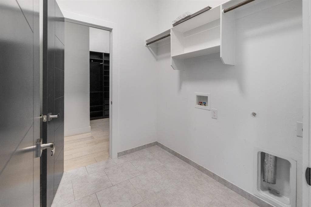 1321 Black Walnut Lane, Arlington, TX 76005 Modern utility space featuring polished concrete flooring, white walls, and open shelving with metal brackets
