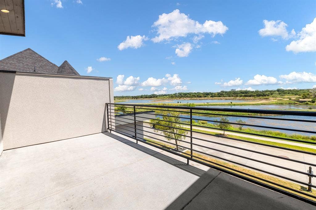 1321 Black Walnut Lane, Arlington, TX 76005 Expansive second-story balcony with horizontal metal railing, concrete decking, and panoramic vistas of manicured grounds and waterfront landscape