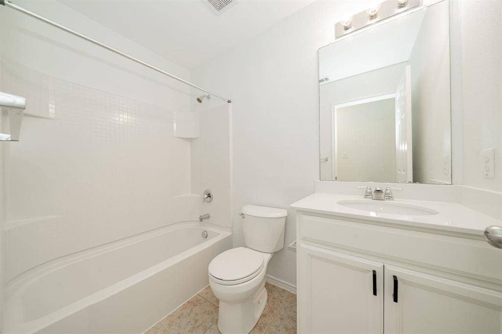 122 Feverbush Drive, Fate, TX 75189 Full bathroom featuring vanity, shower combination, and tile patterned flooring